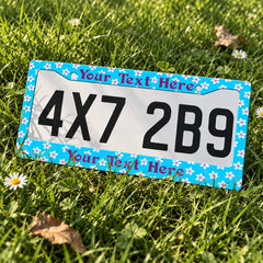 Personalized Turquoise Tropical Flowers license plate frame displayed on a plate outdoors