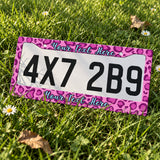 Custom Pink Leopard Print license plate frame displayed on a plate outdoors