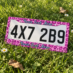Custom Pink Leopard Print license plate frame displayed on a plate outdoors