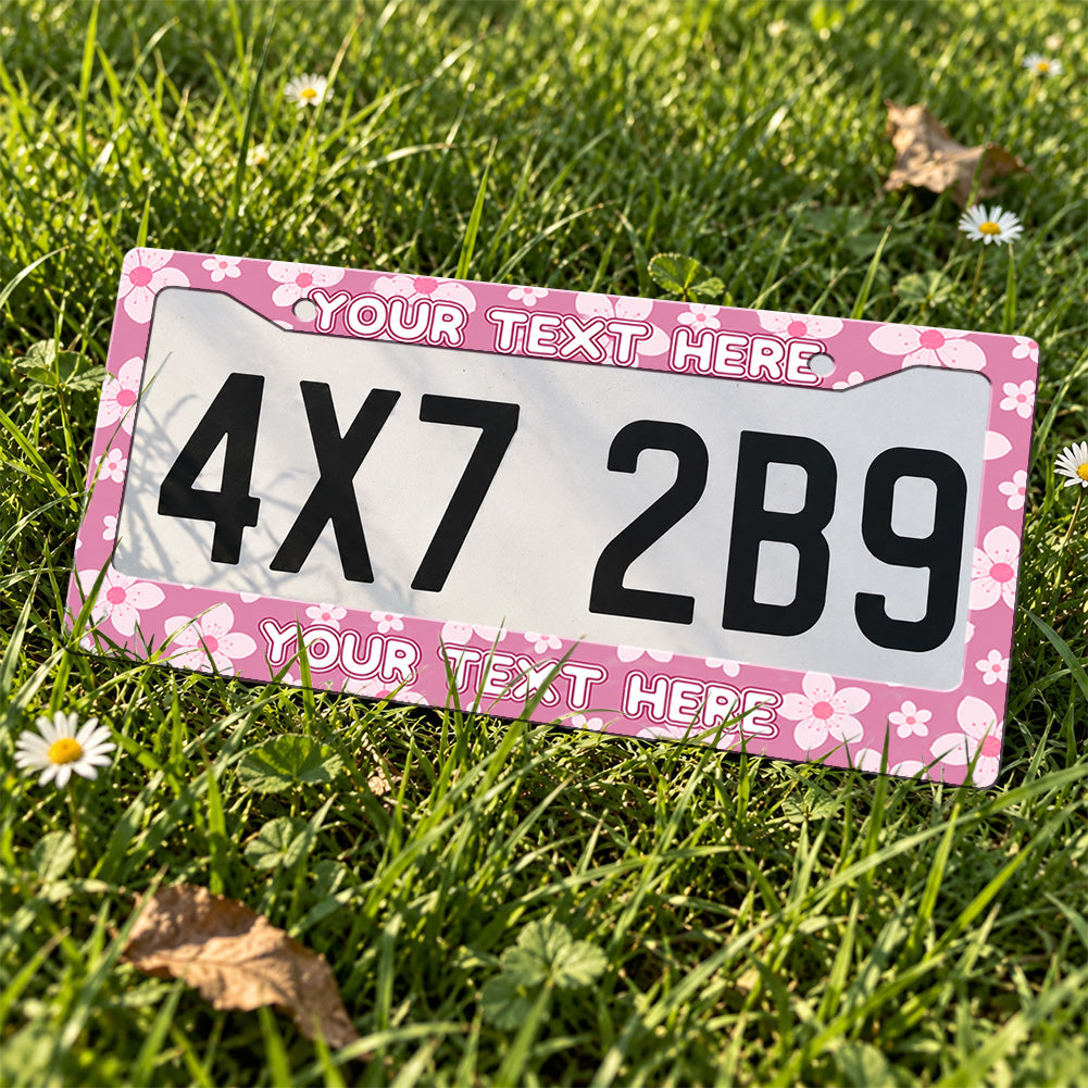 Personalized Pink Cherry Blossom license plate frame displayed on a plate outdoors