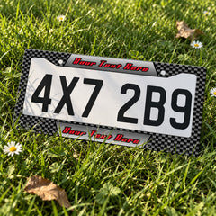 Custom Carbon Fiber Racing license plate frame displayed on a plate outdoors