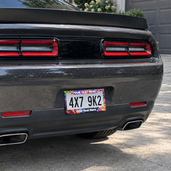Space Cats and Food license plate frame installed on a black sports car