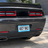 Turquoise Tropical Flowers license plate frame installed on a black sports car