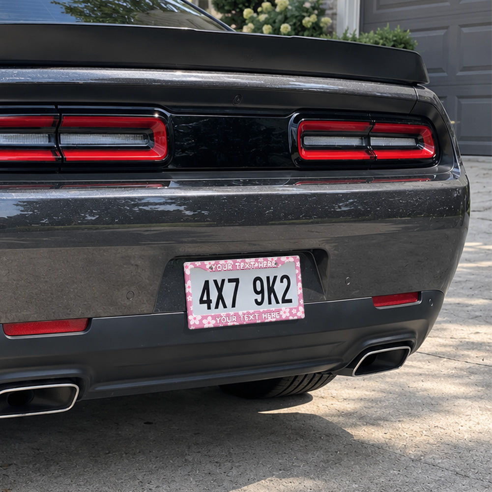 Pink Cherry Blossom license plate frame installed on a black sports car