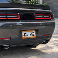 Rustic Burnt Orange license plate frame installed on a black sports car