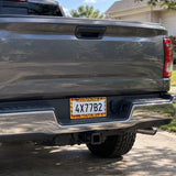 Melting Cheese and Pizza license plate frame installed on a pickup truck