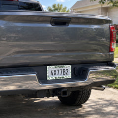 Green Botanical Leaves license plate frame installed on a pickup truck