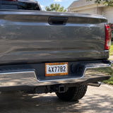 Custom Rustic Burnt Orange license plate frame installed on a pickup truck